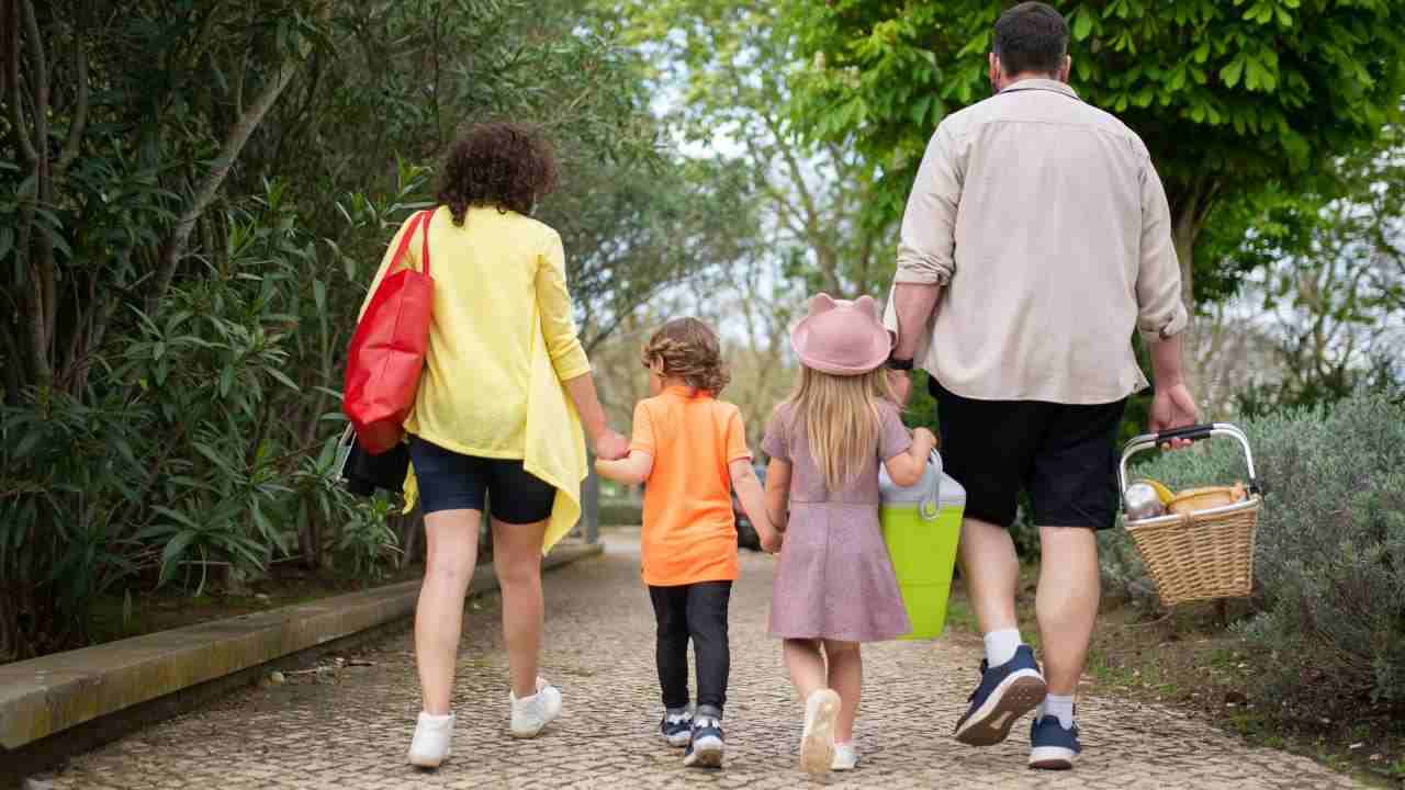 Famiglia che passeggia di spalle nel verde