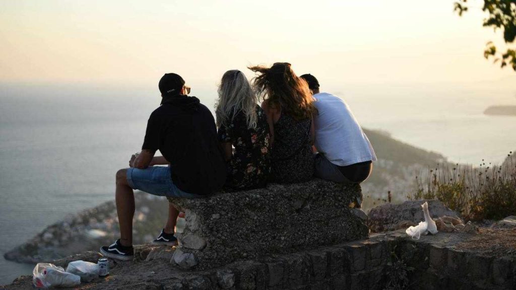 Amici_ragazzi seduti guardano l'orizzonte